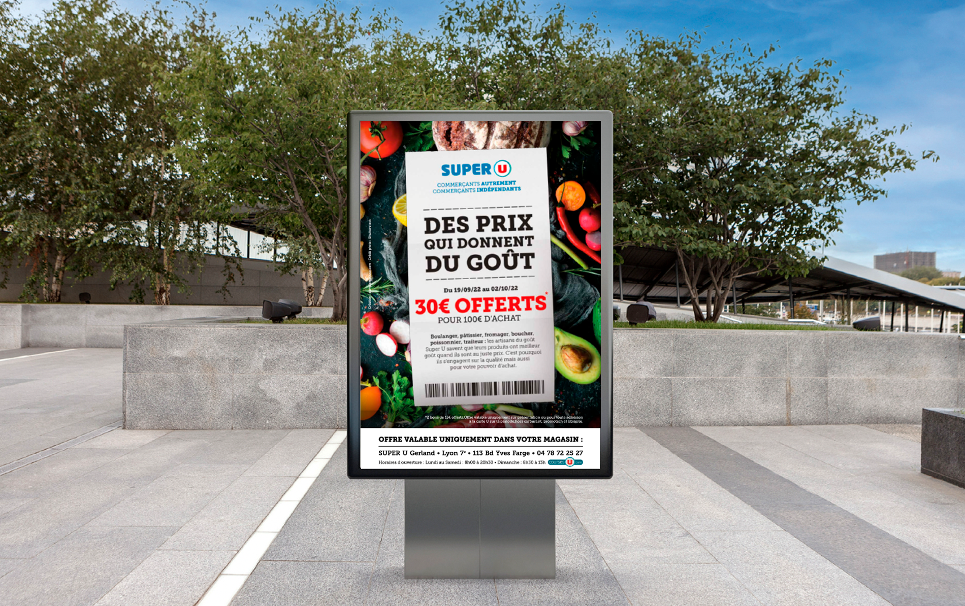 Affiche éxterieur pour la promotion en cours chez Super U présente un fond avec une photographie de fruits et légumes, incluant des agrumes, des avocats, des poivrons et des tomates. Au centre du flyer se trouve un ticket de caisse de Super U avec un message promotionnel indiquant que les clients pourront bénéficier de 30 € de réduction pour chaque achat de 100 € ou plus effectué entre le 19 septembre 2022 et le 2 octobre 2022 au Super U de Gerland, situé dans le 7ème arrondissement de Lyon.